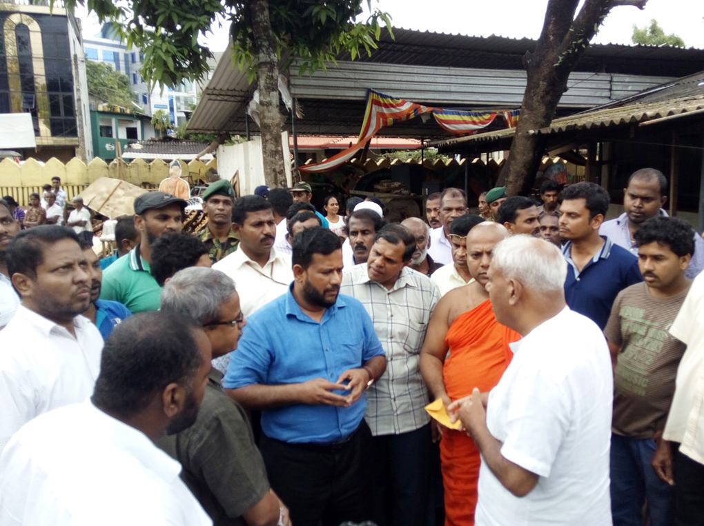 Minister of Industry and Commerce Rishad Bathiudeen (centre) visits the flood hit Sri Bodhirajarama Viharaya in Ratnapura on June 3 and hands over a cash donation of Rs 100,000 for the temple's post flood cleaning work to the temple's incumbent Venerable monk.