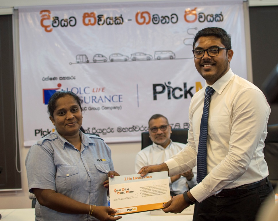 PickMe Chief Executive Officer Jiffry Zulfer handing over a life insurance cover to one of the women drivers at PickMe