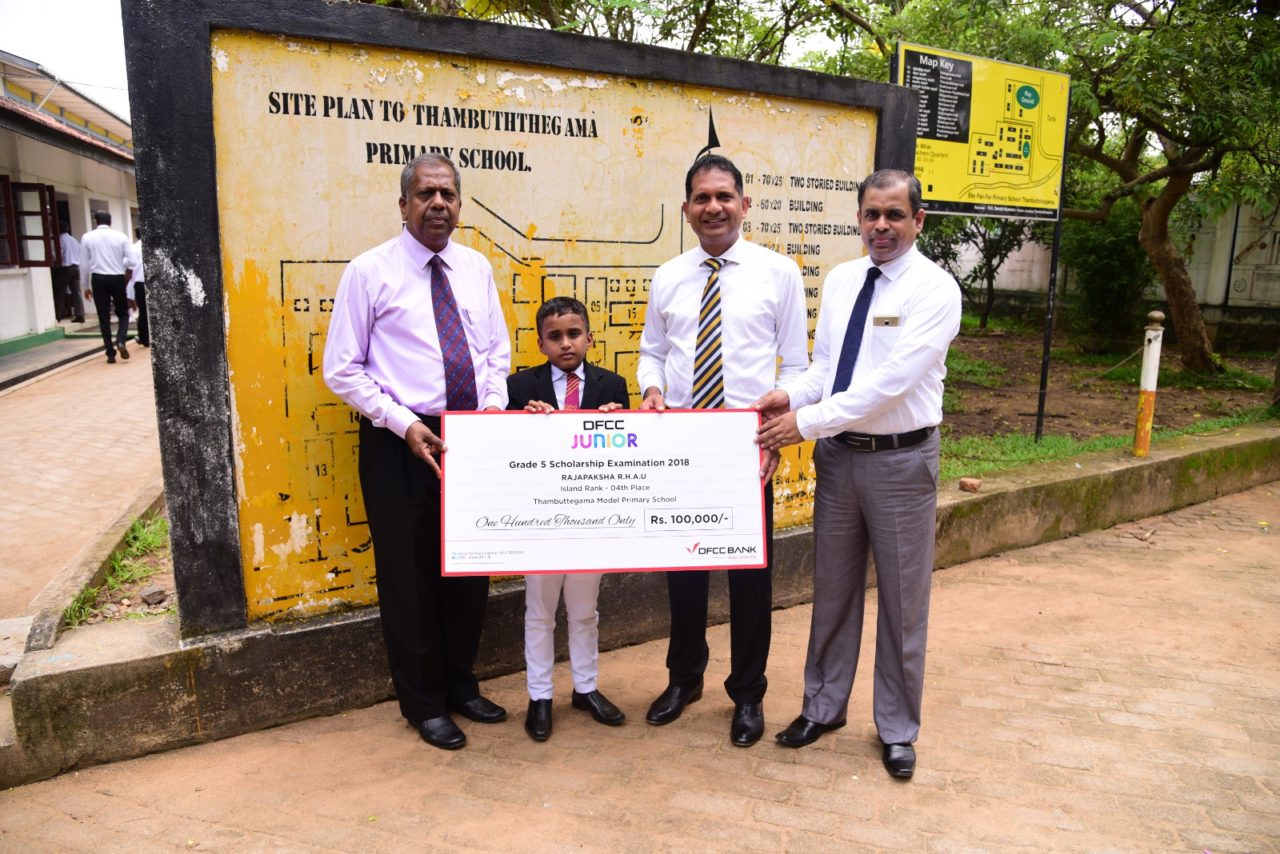 Image 1 - Ayodya Udan Rajapaksha of AThambuttegama Model Primary School receives his cheque from DFCC's Candiah Jegarajah Regional Manager Anton Arumugam - V (002)