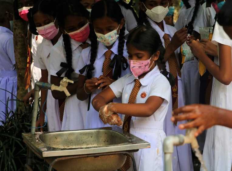 2.A young student of the Maniyangama Maha Vidyalaya in Dehiowita, setting an example as she demonstrates the steps of handwashing as she is earnestly observed by her classmates. (LBN Fill)